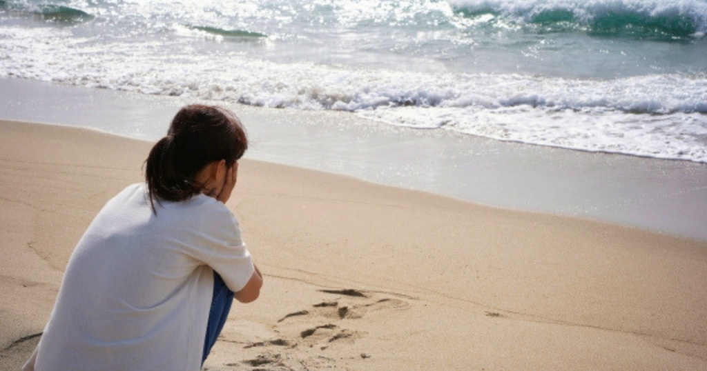 「なんとなく怖い」のはなぜ？離婚・お金・生活の変化で感じるグリーフ　海辺で悩む女性